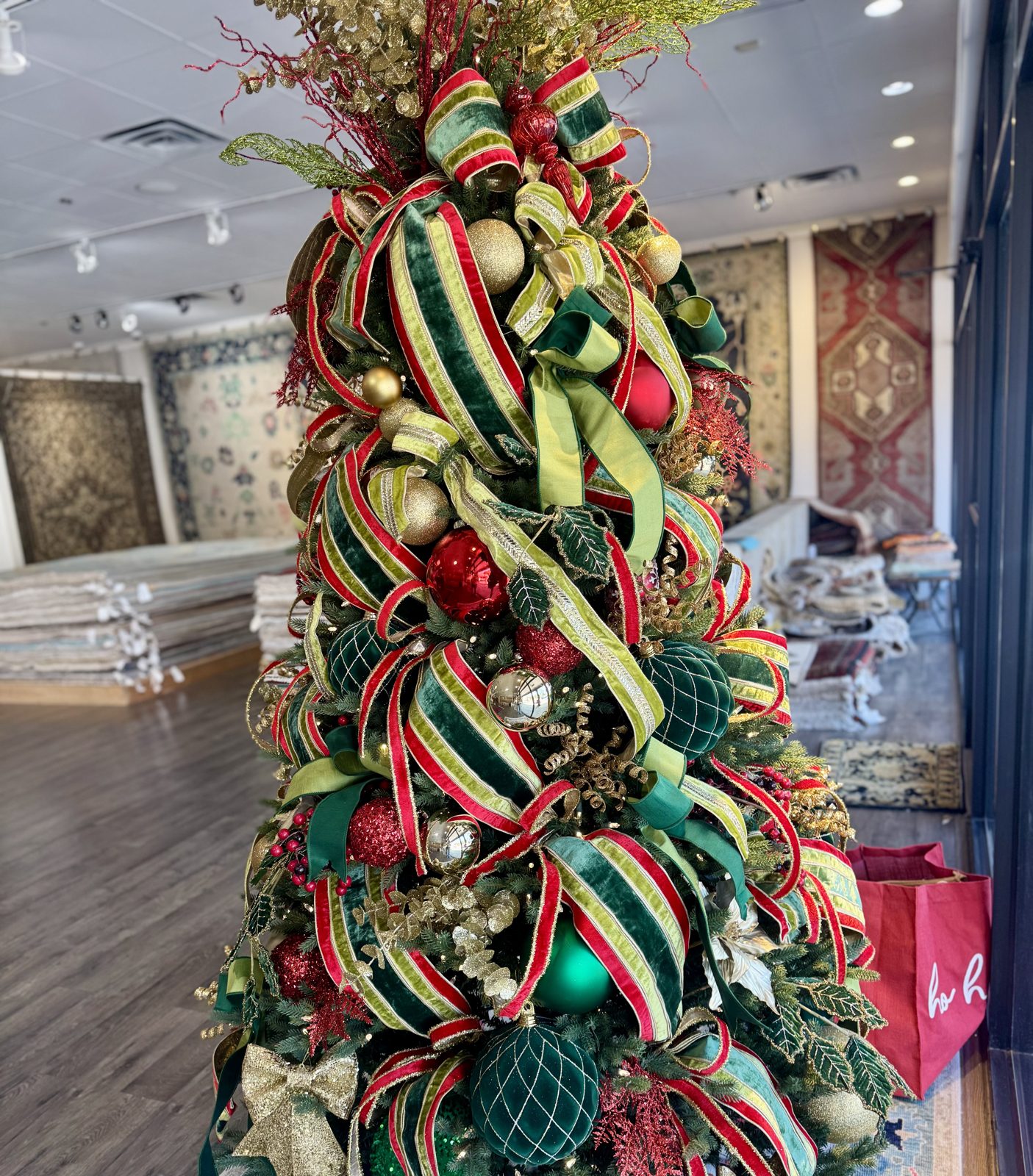 Elegantly decorated Christmas tree with gold ornaments in a cozy living room